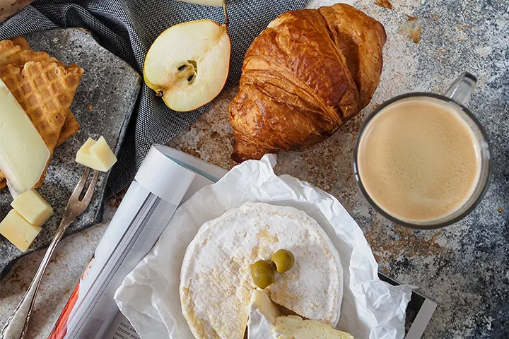 Frukostbord med croissant, camembert och kaffe